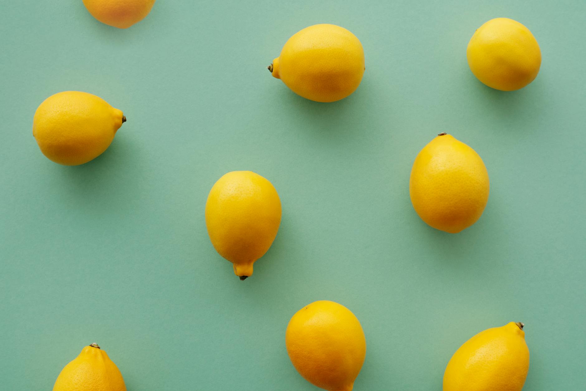 Fresh yellow lemons arranged on a soft green background, symbolizing renewal and healing