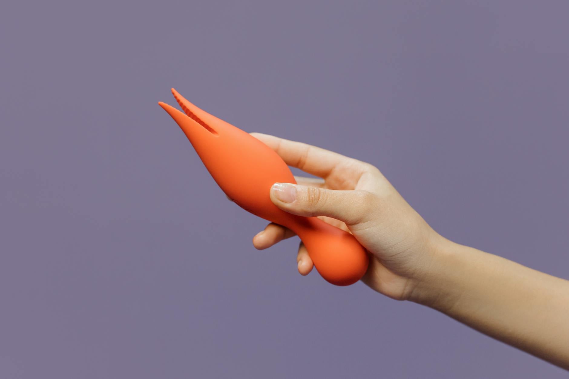 A hand holding a lemon-colored vibrator against a minimalistic purple backdrop, symbolizing gentle self-reclamation and healing.