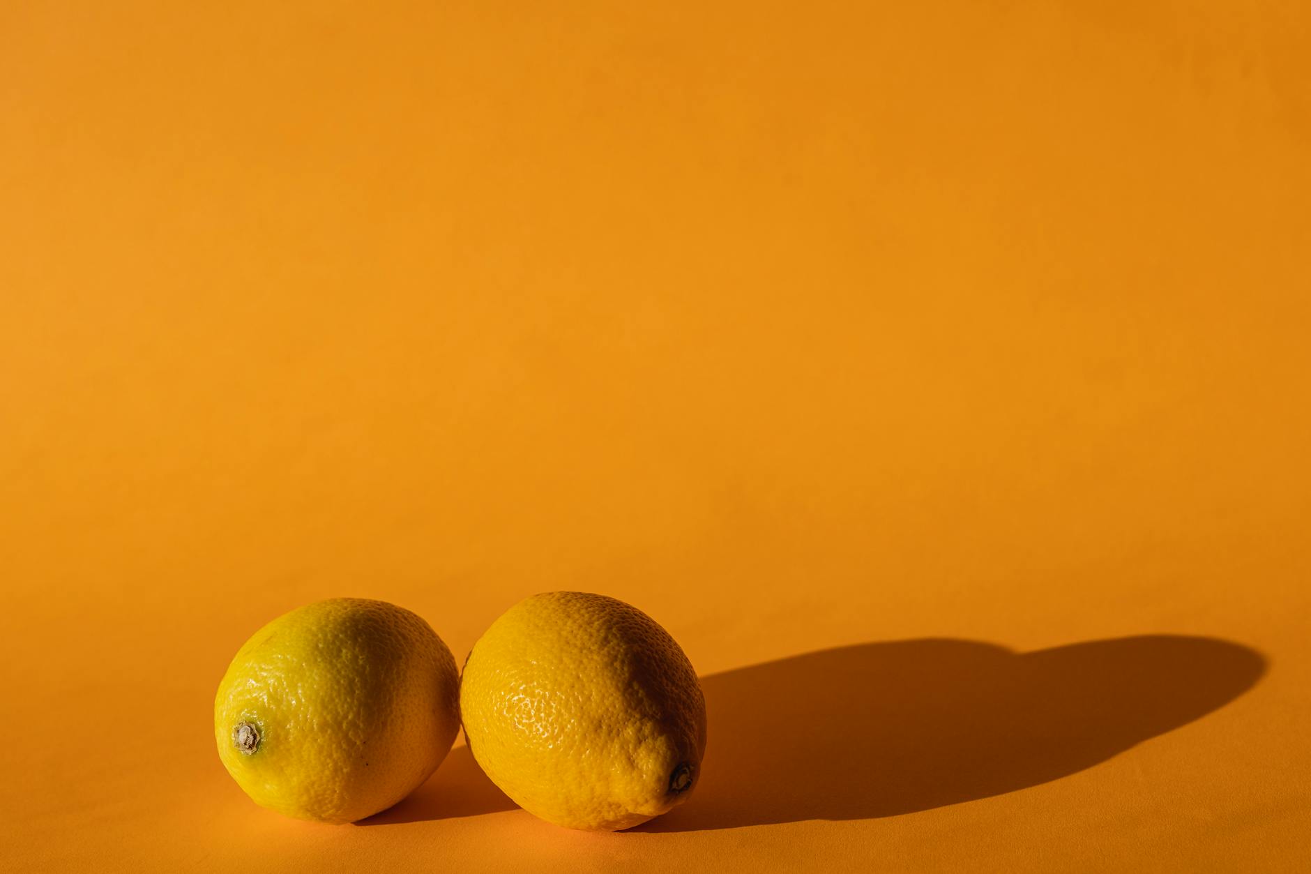 Ripe vivid lemons on a bright yellow background
